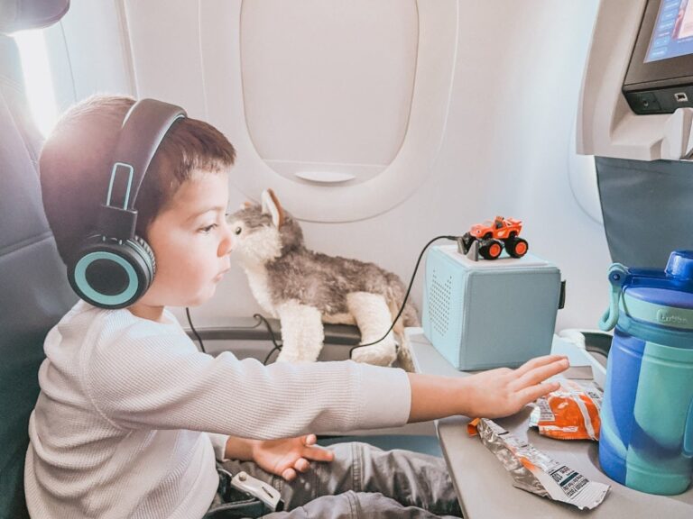 boy eating snacks on airplane during a long flight with kids